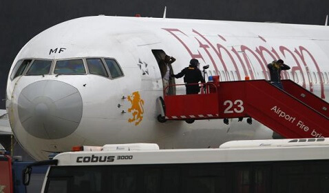 Police officers help passengers disembark from the hijacked Ethiopian Airlines flight ET 702 at Cointrin Airport in Geneva